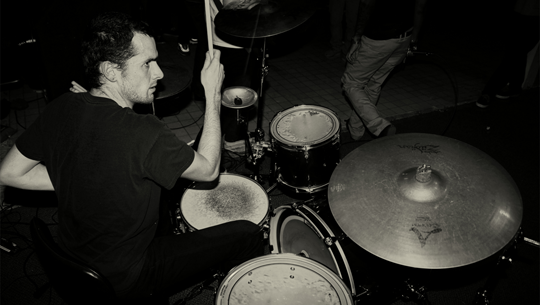 Crossface's drummer performing their first live show at The Cave. | Photo by Robert Angus