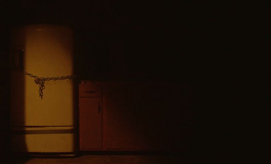 A locked fridge sits in darkness