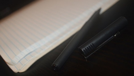A pen lies before paper