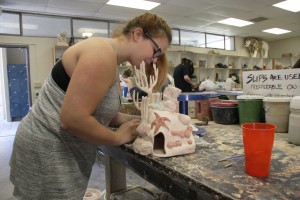 Yuba College student Haley Hurst paints her fish decor ceramics project. (Photo taken by Regina Hernandez)
