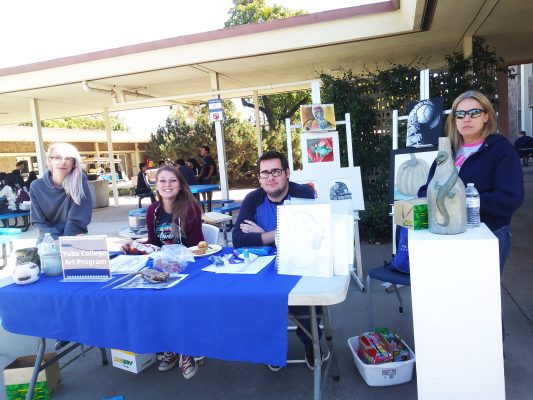 Yuba college art students sitting at booth